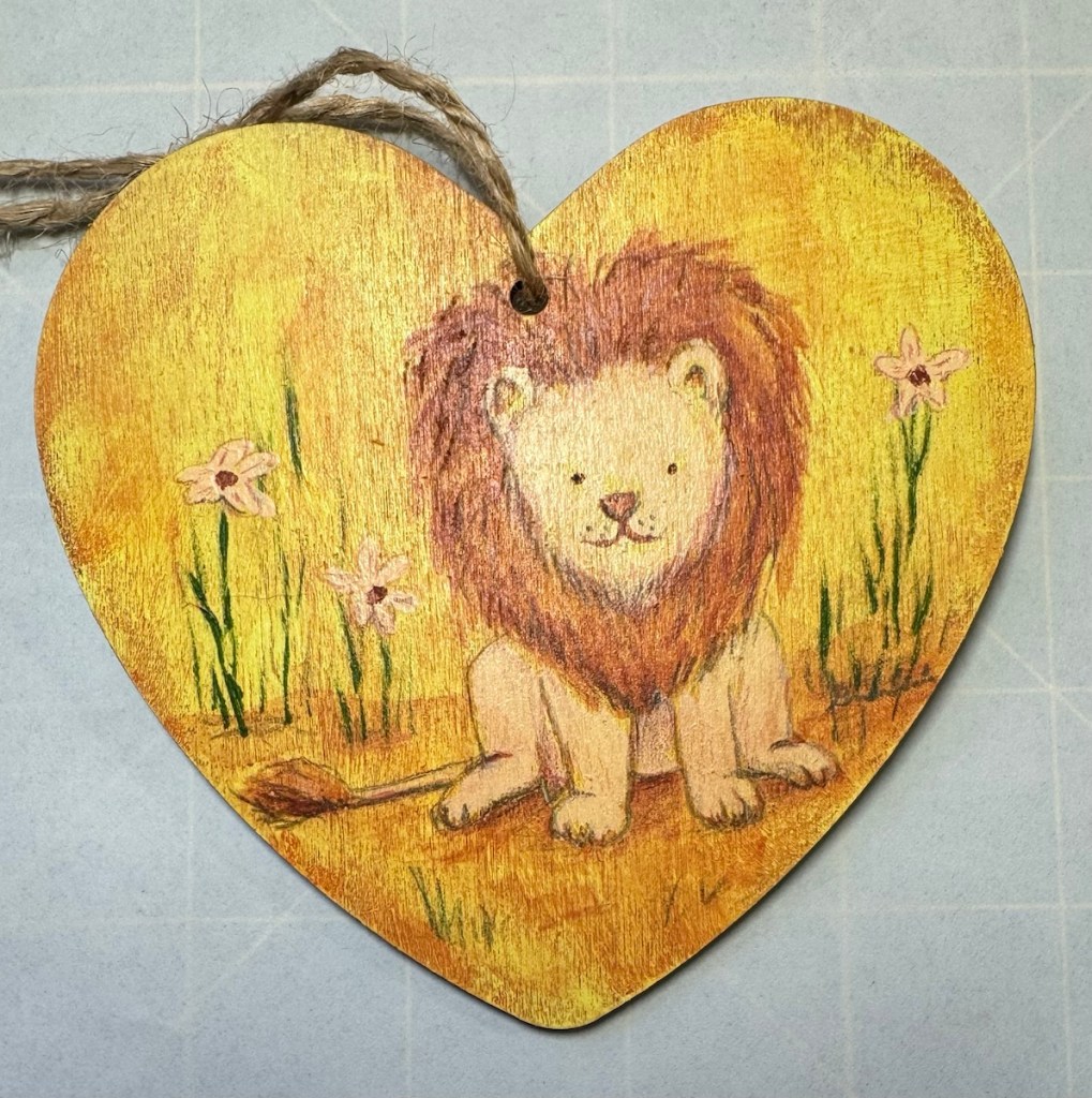 Heart shaped art of a lion done with burnt umber and a pale peach.  The whole heart was down with only 4 colors, the background, which was glazed over...the 2 colors for the lion and the green for the plants.  Values were added with color pencil.
